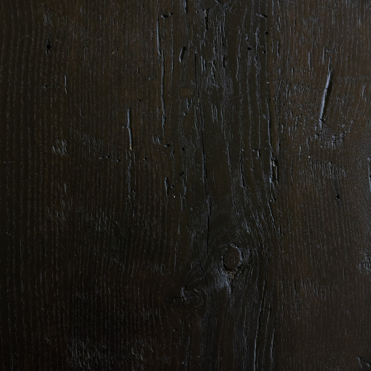 Close-up of a dark wooden surface with visible grain and texture